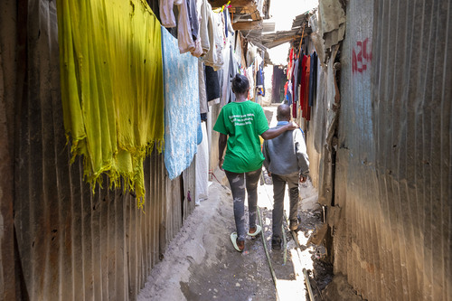 Kenia / BSIN Vorarlberg Sozialarbeiterin und Stanley Maina, ein auf der Straße lebender Junge im Mukuru Slum, Nairobi in Kenia